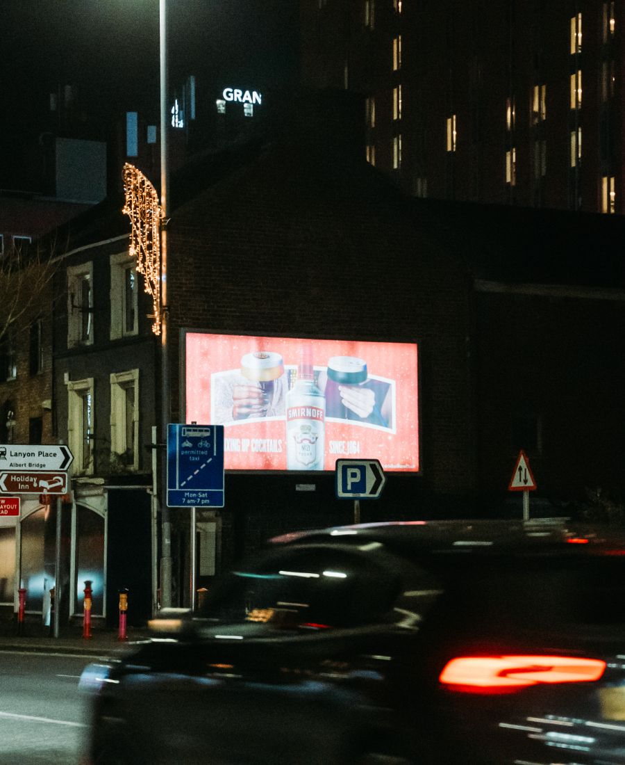 car driving by smirnoff ice ad at night on great victoria street